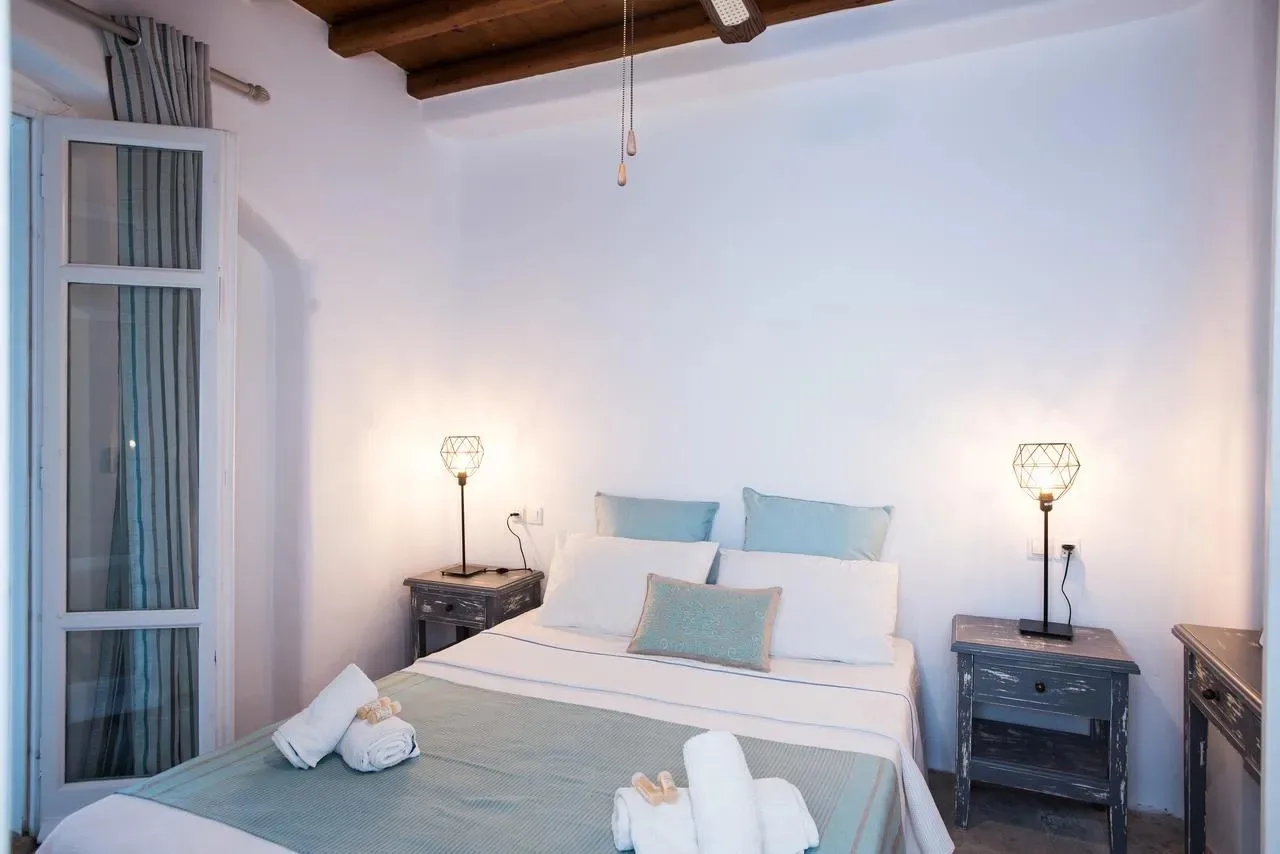 Un dormitorio con una cama bien tendida y mesitas de noche a juego.