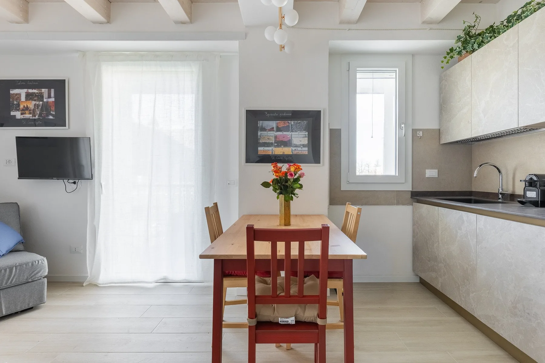 Un comedor con una mesa de madera y sillas junto a una cocina compacta.