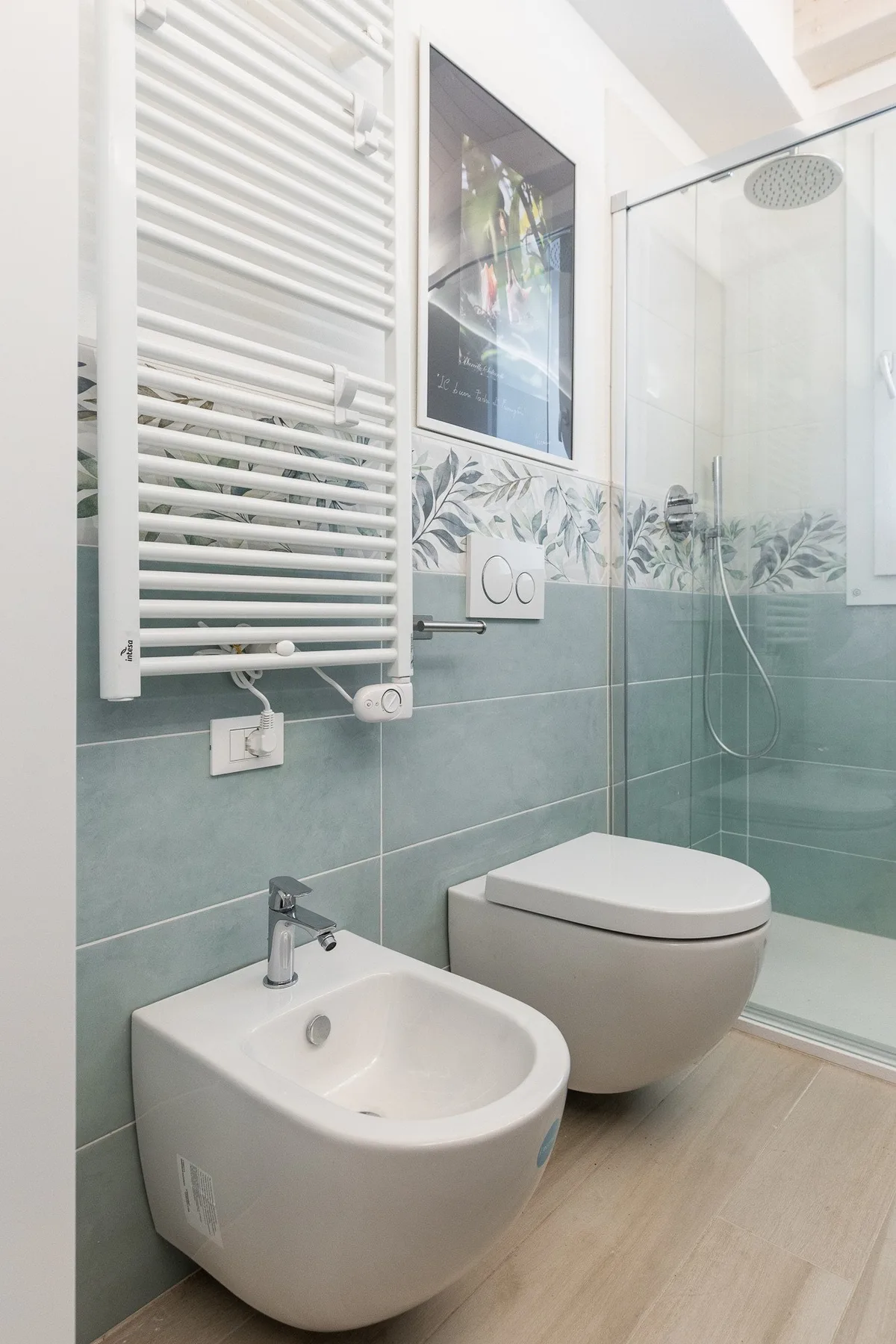 Un baño moderno con lavabo suspendido y ducha de cristal.