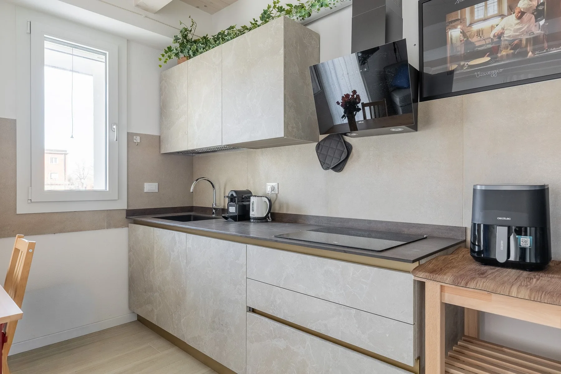Una cocina moderna y luminosa con encimera, fregadero y zona de cocción.
