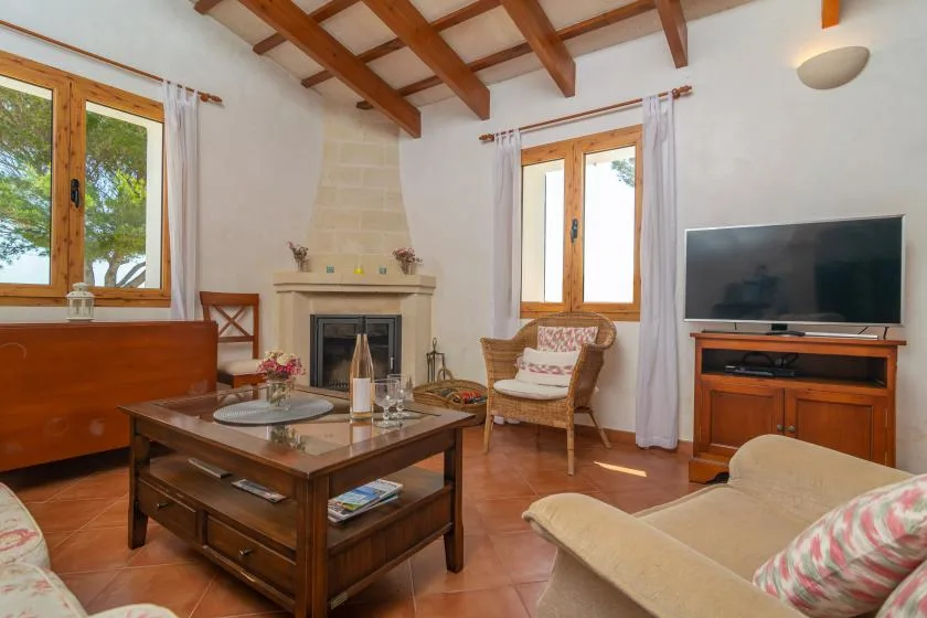 Una sala de estar con chimenea, mesa de centro de madera y televisor.