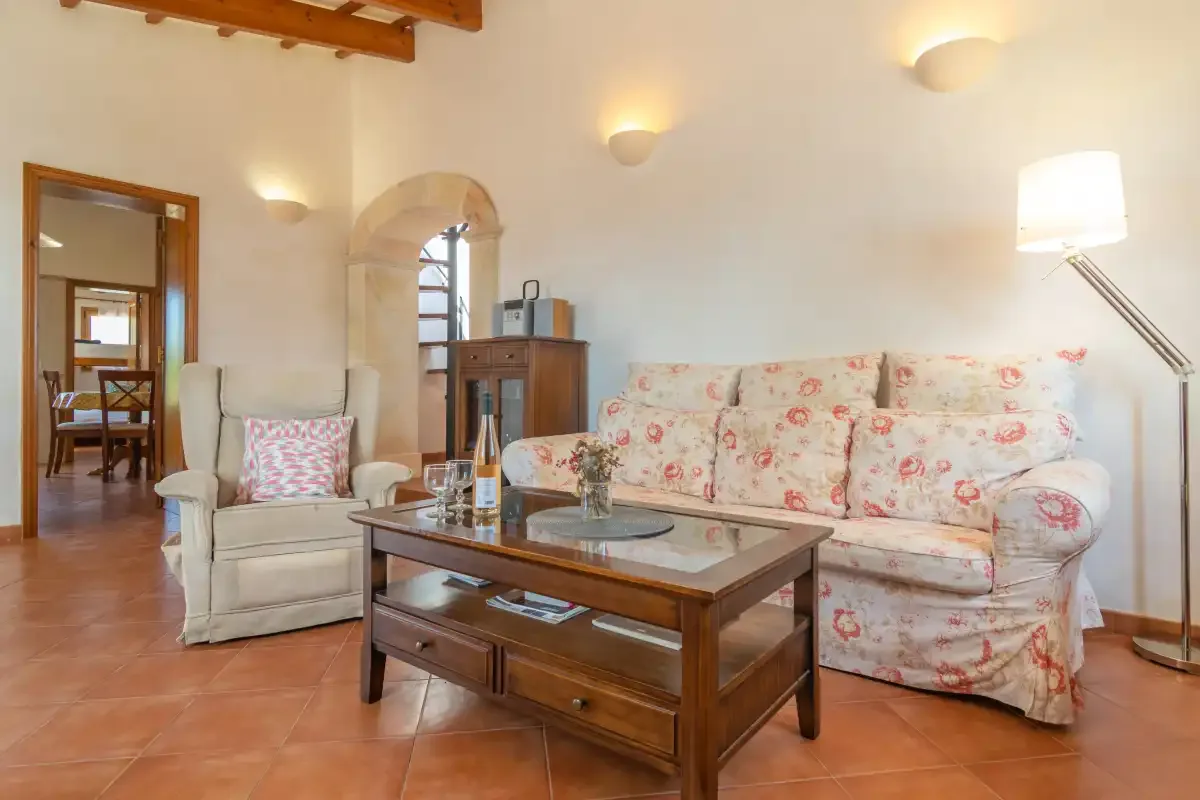 Una sala de estar con asientos florales y una mesa de centro de madera.