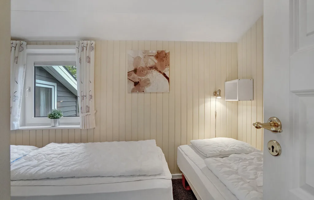 Un dormitorio con dos camas y una ventana con cortinas.