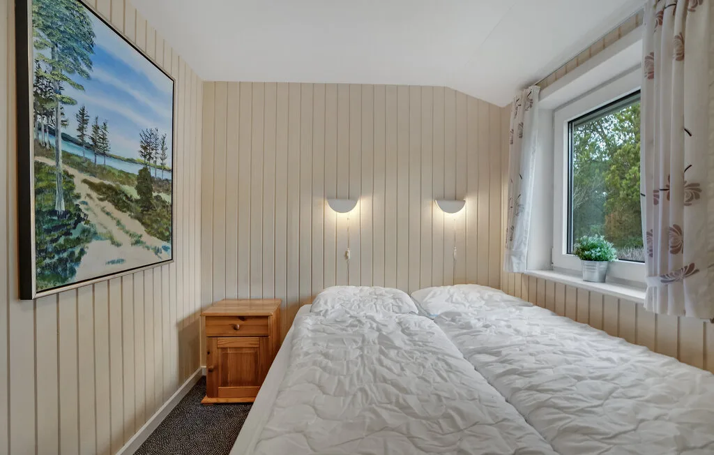 Un dormitorio con dos camas bajo luces de pared y una ventana.