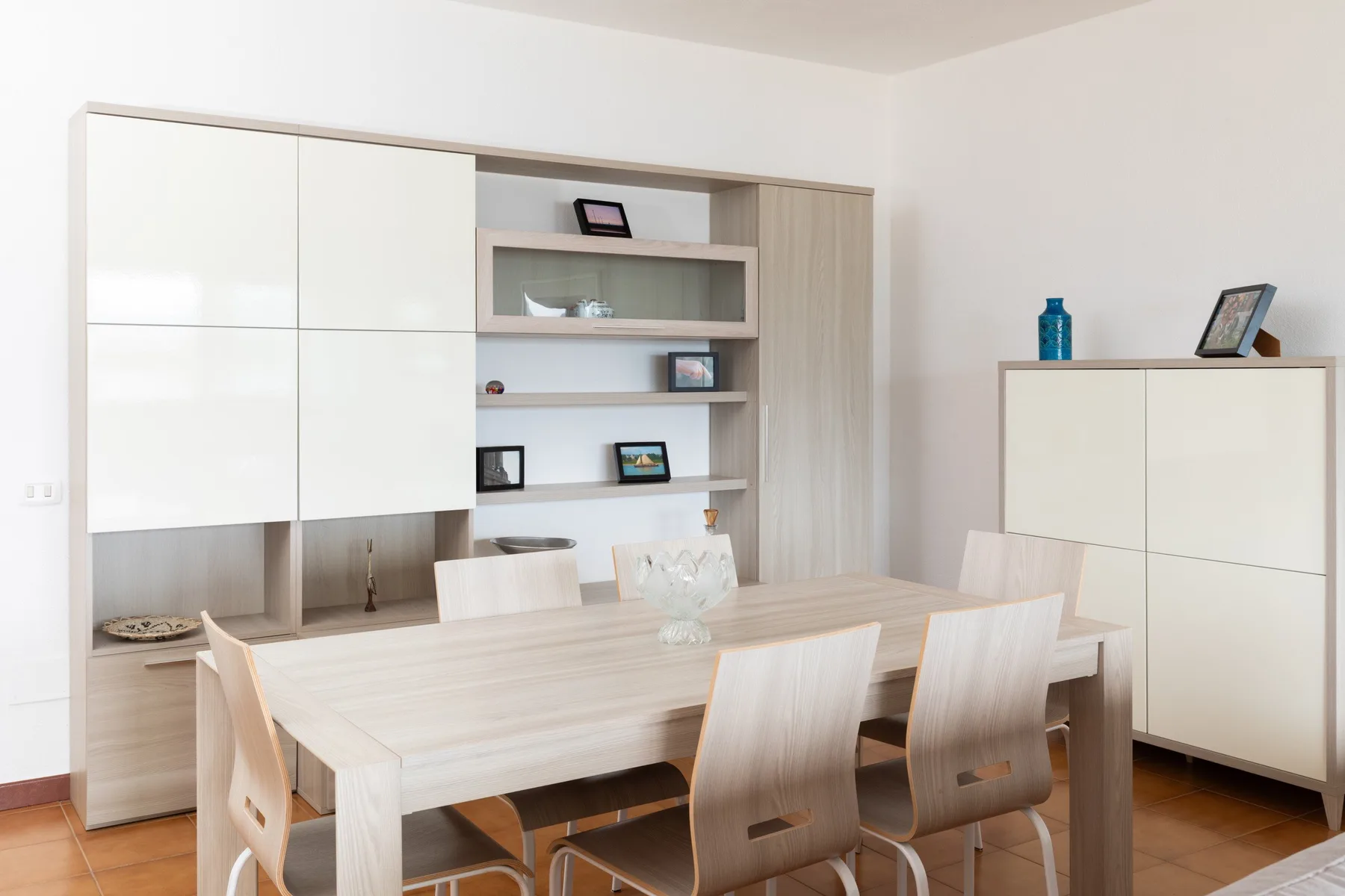 Un comedor luminoso con una mesa larga y asientos alrededor.