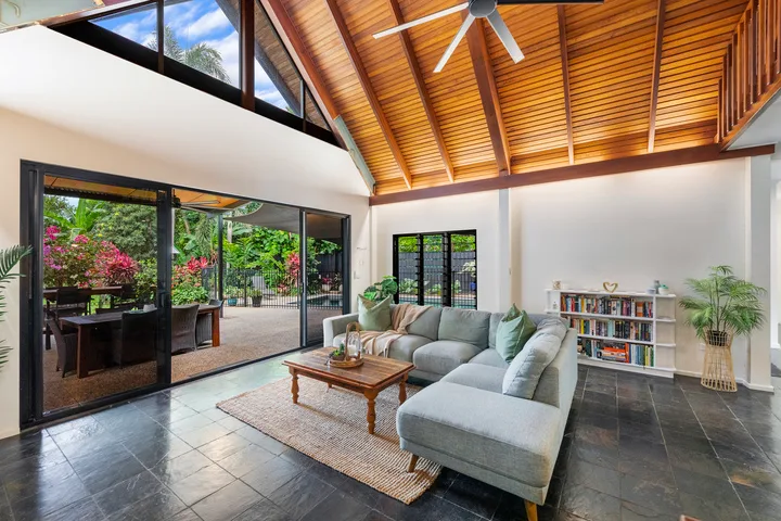 A bright living room with a sectional sofa, coffee table, and vaulted wood ceiling.