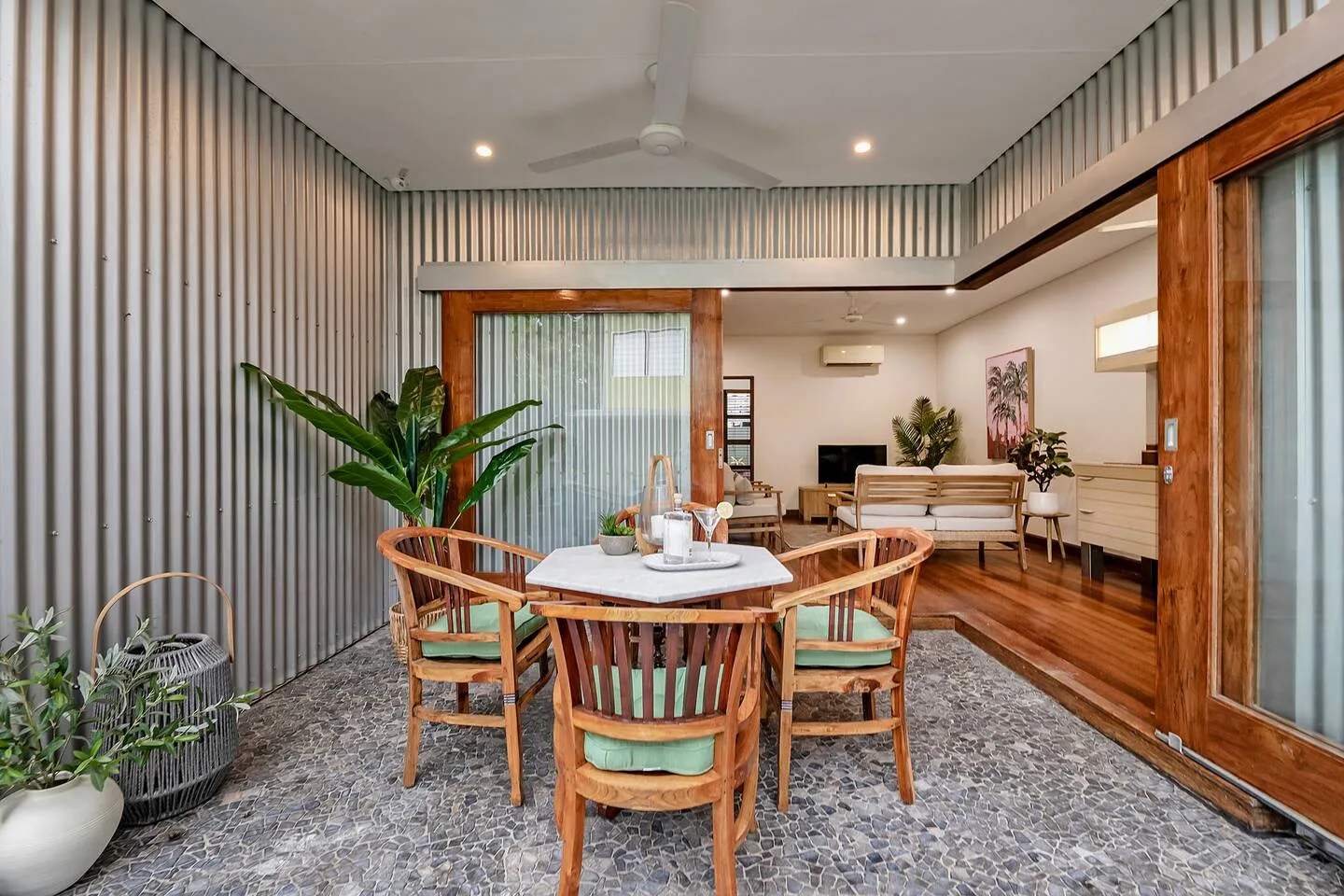 A furnished patio dining area with a round table and surrounding seating.