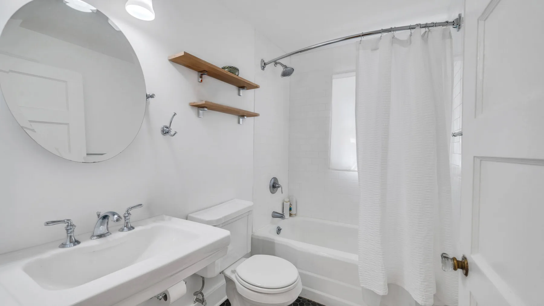 Un baño con lavabo, inodoro y bañera detrás de una cortina de ducha.