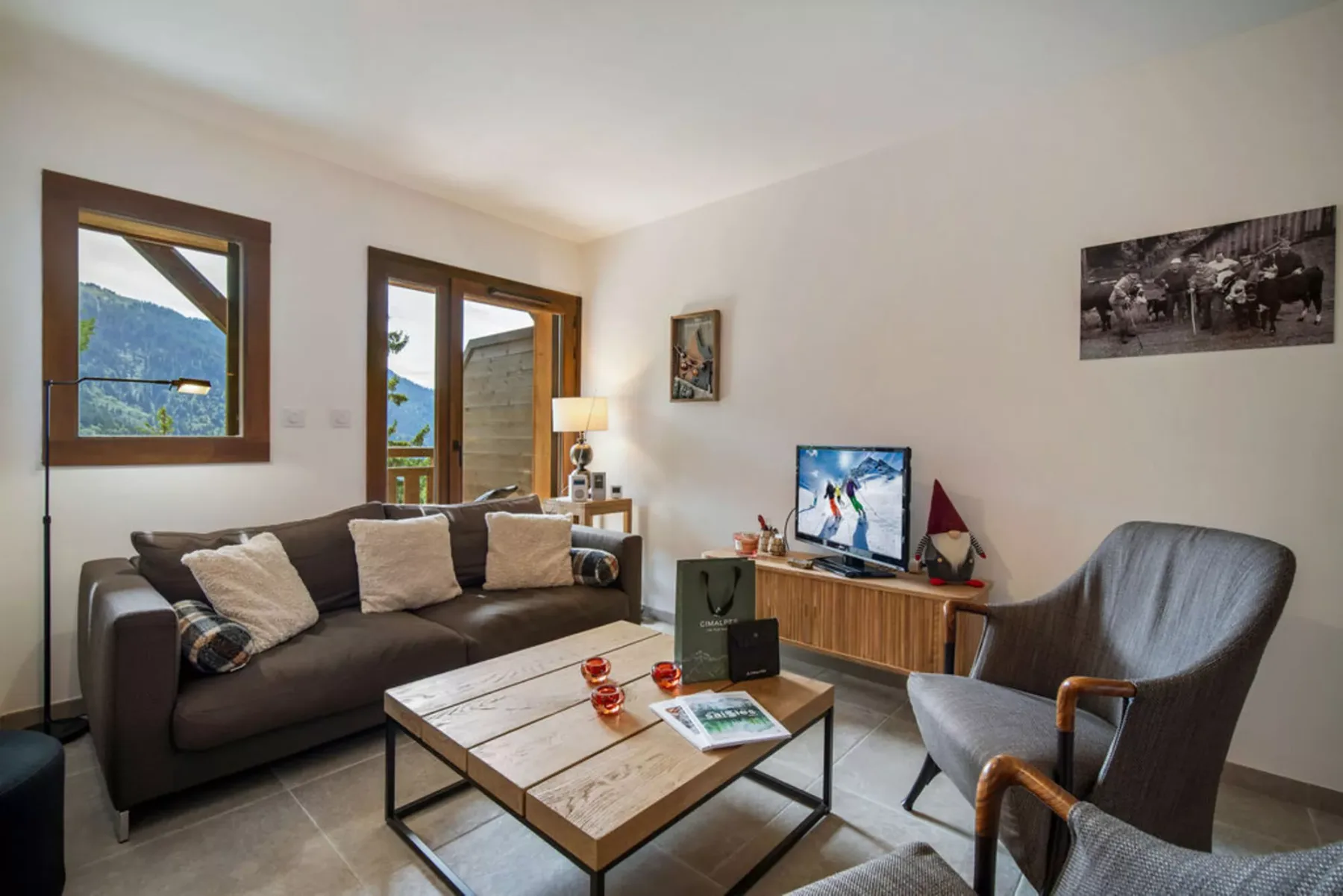 A living room with seating around a coffee table and a television.