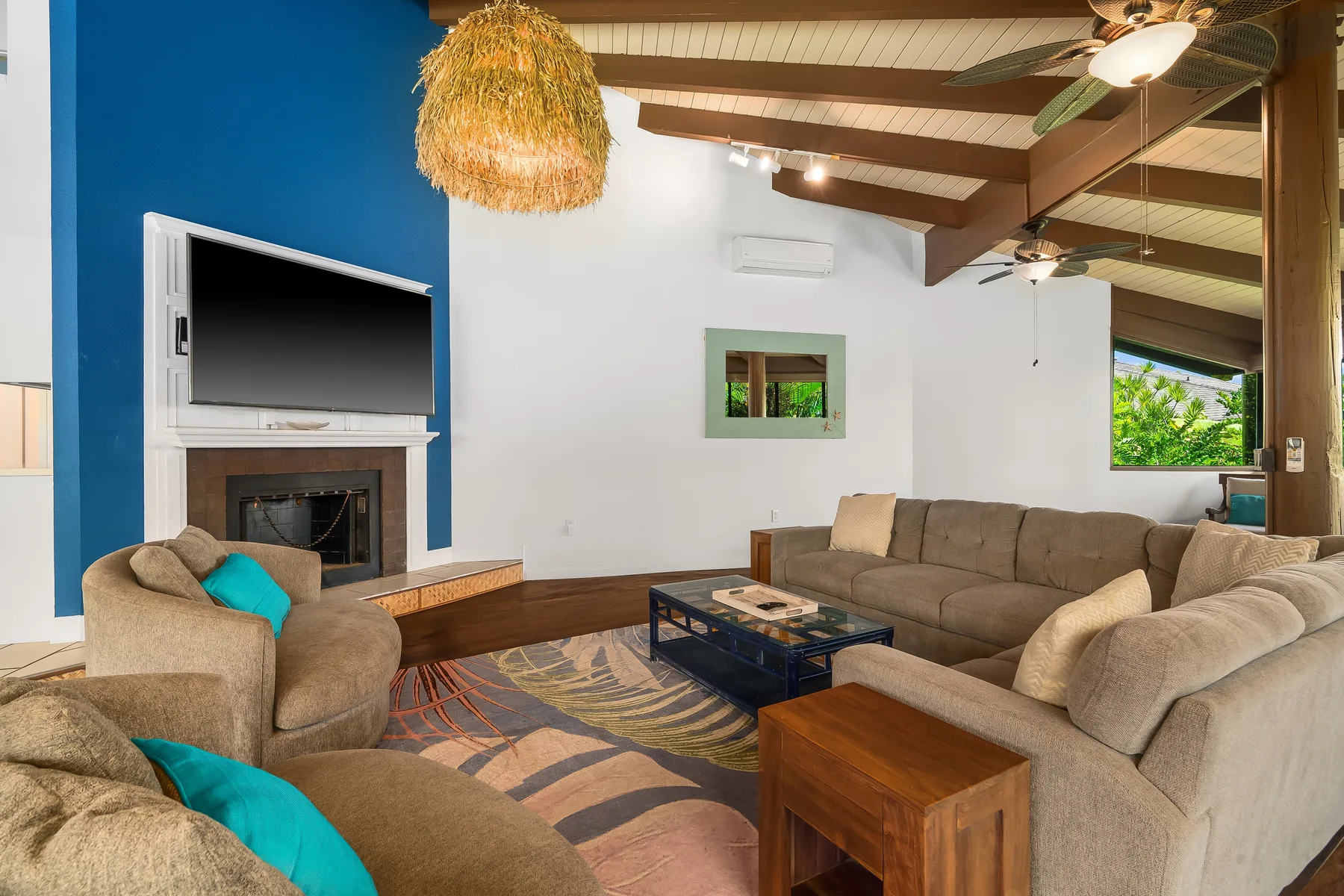 A living room with seating arranged around a coffee table and fireplace.
