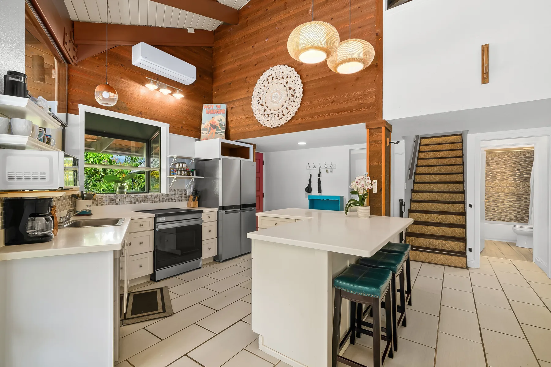 A kitchen with a central island and wooden walls.