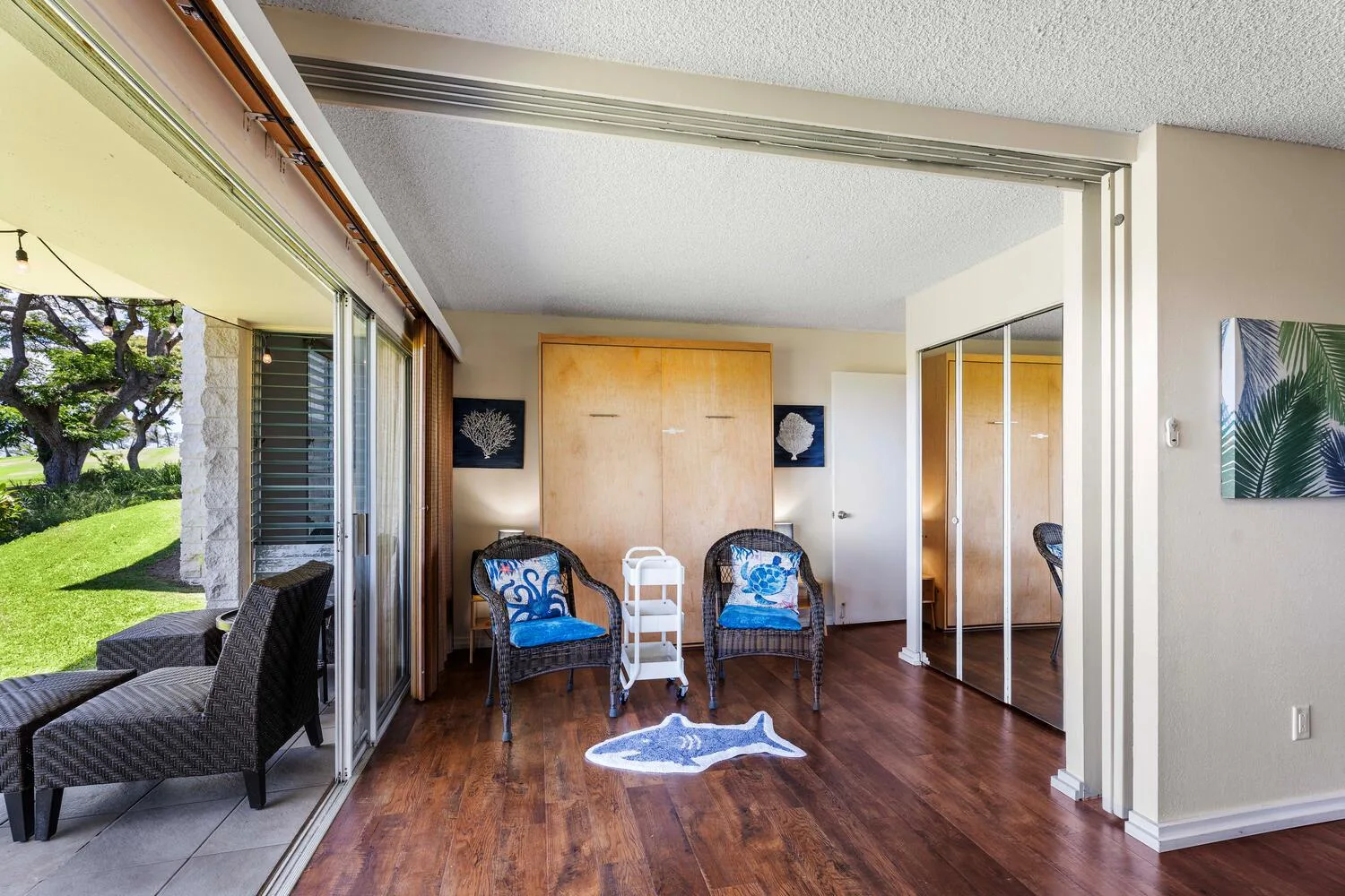 Un dormitorio con suelo de madera, asientos y puertas de armario con espejo.