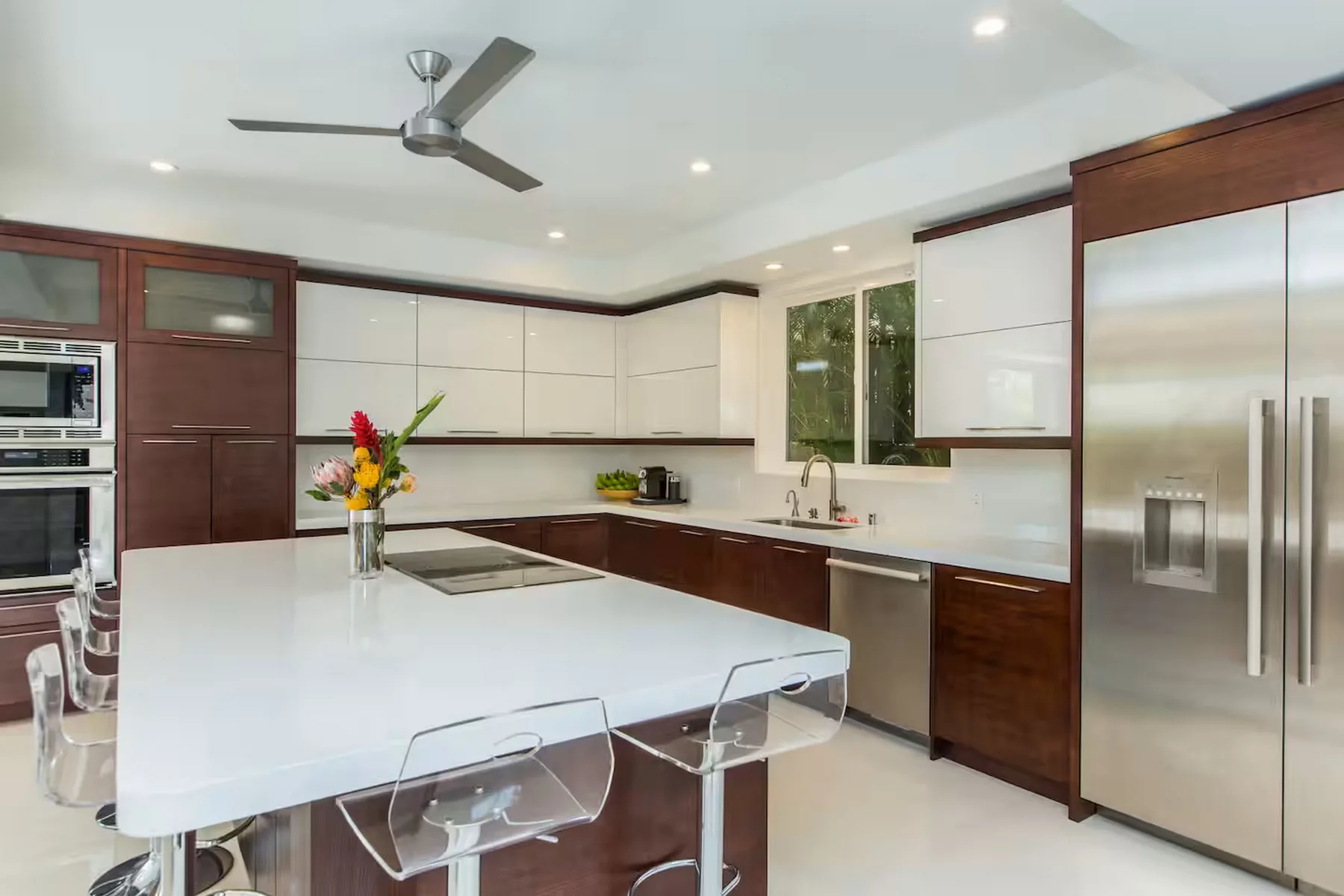 Una cocina moderna con una gran isla blanca y electrodomésticos de acero inoxidable.
