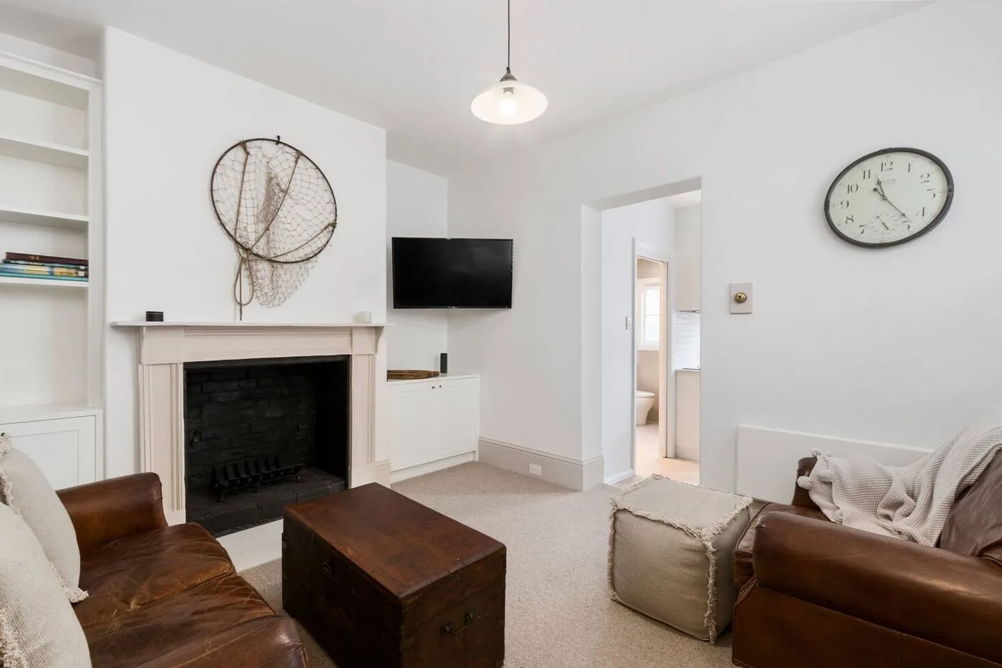 Una sala de estar con chimenea, televisión y asientos.