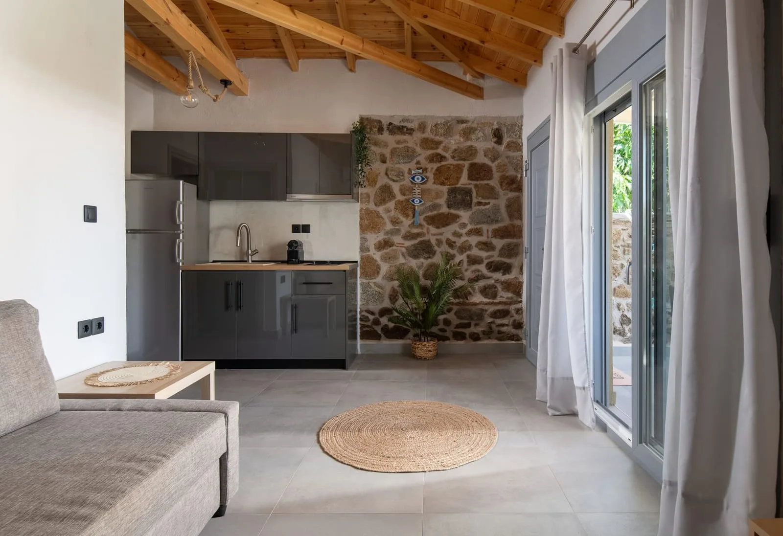 Cocina equipada con pared de piedra y refrigerador