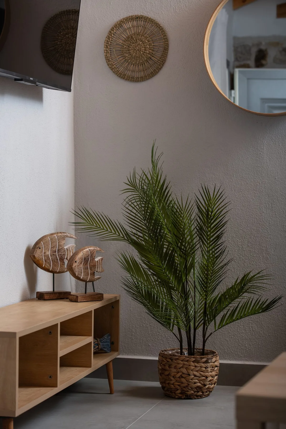 Decoración interior con planta, espejo y muebles de madera