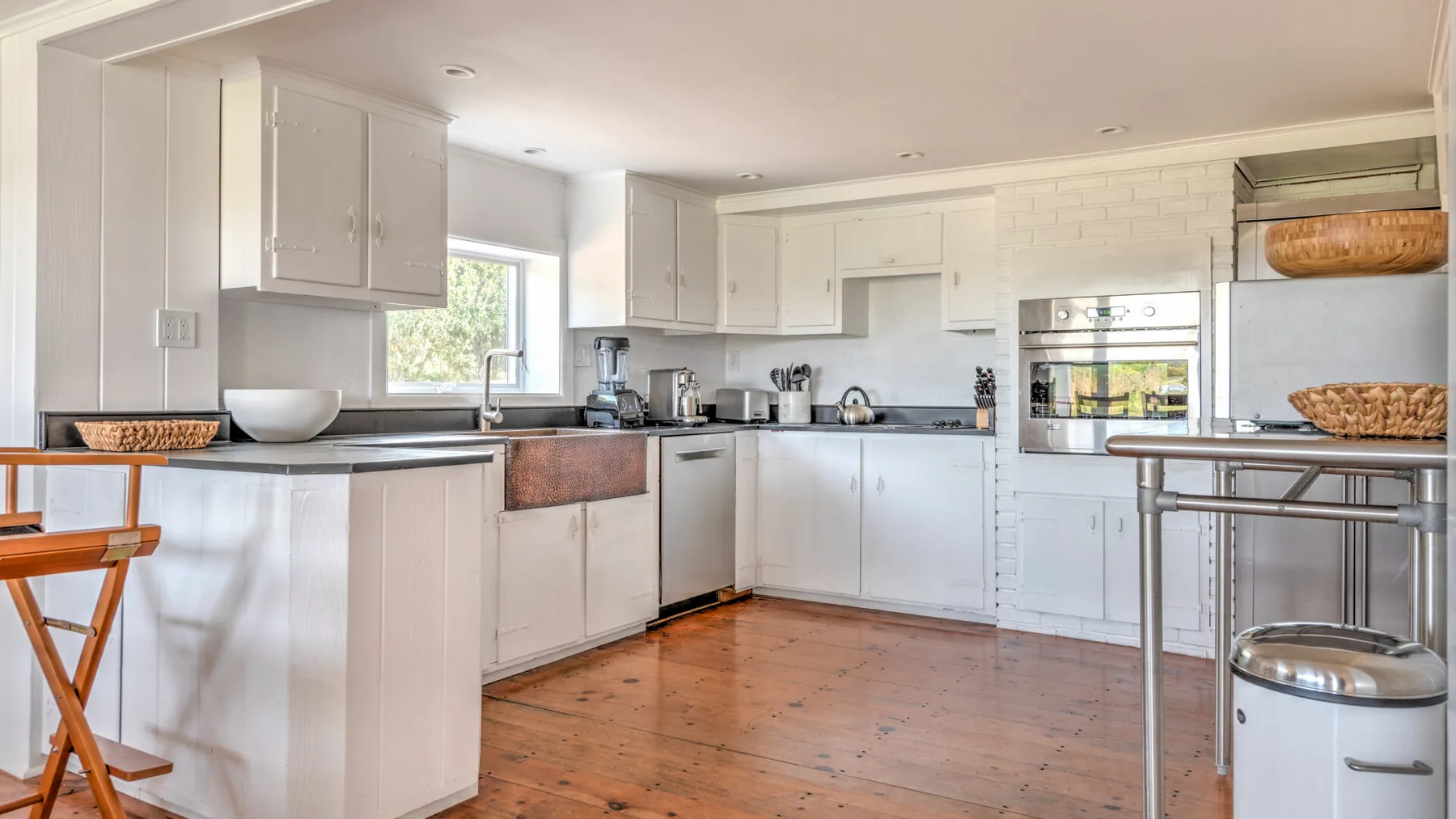 A bright kitchen with white cabinets, a countertop, and a central cooking area.