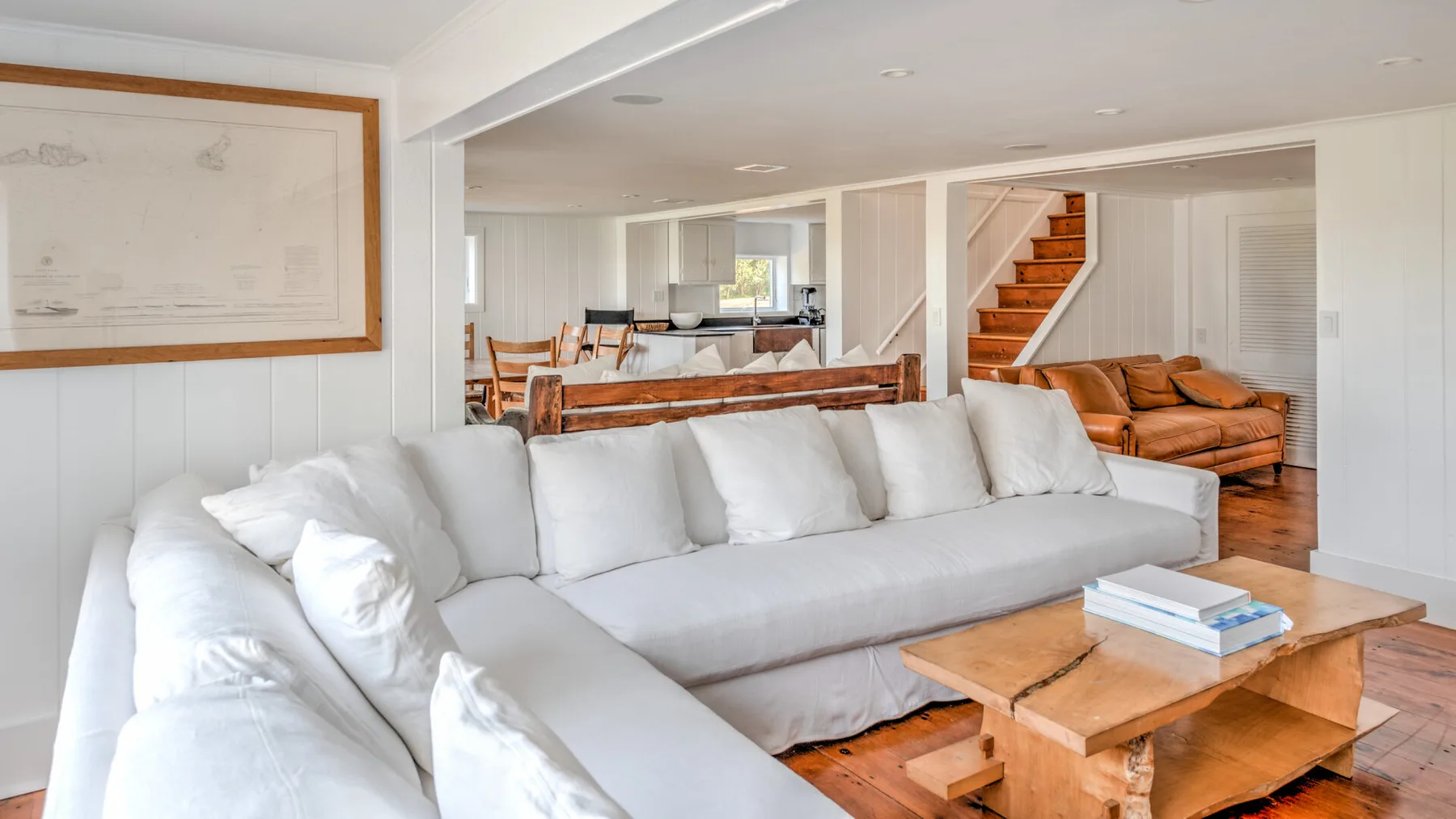 Una sala luminosa con asientos blancos y una mesa de centro de madera.