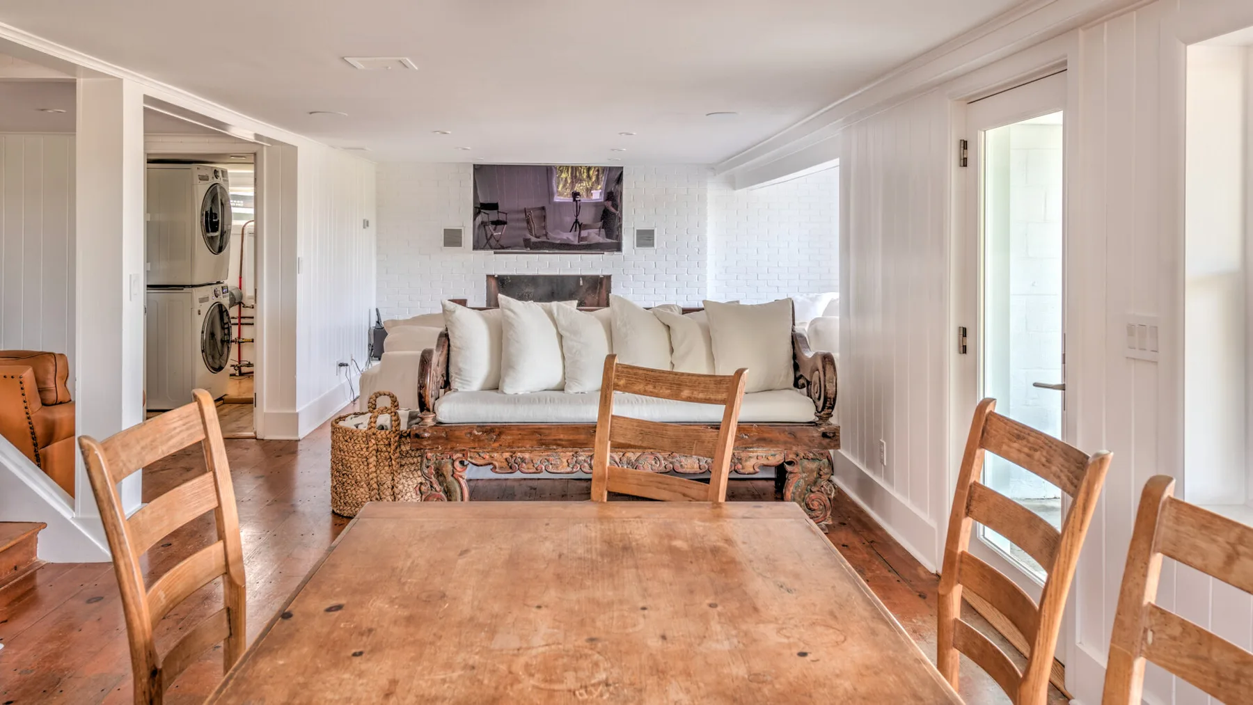 Una luminosa sala de estar y comedor con asientos alrededor de una mesa de madera.