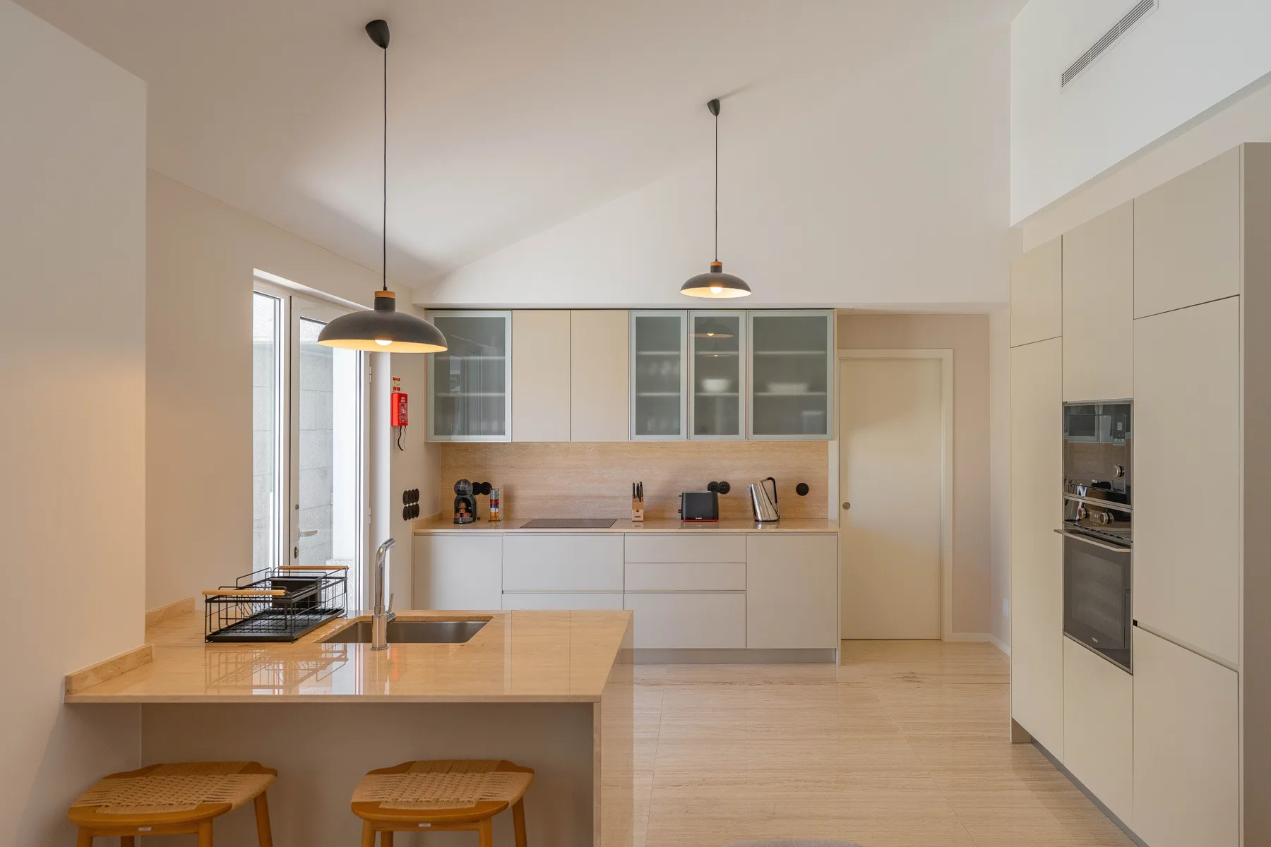 A modern kitchen with a large island and pendant lights.
