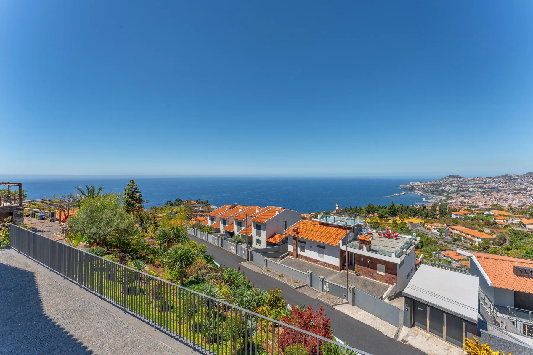 A coastal residential neighborhood with orange roofs overlooks the sea.