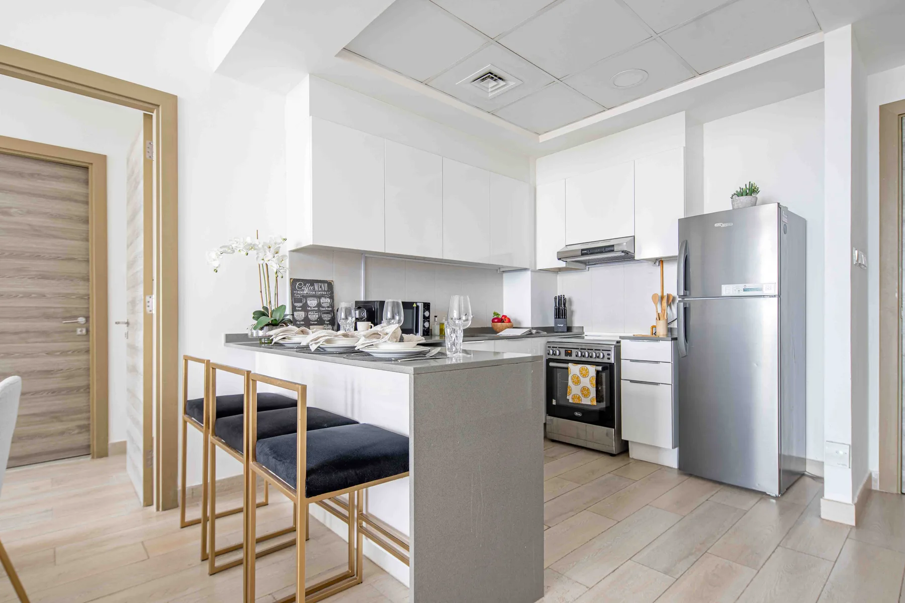 A bright kitchen has a central island with seating and stainless steel appliances.