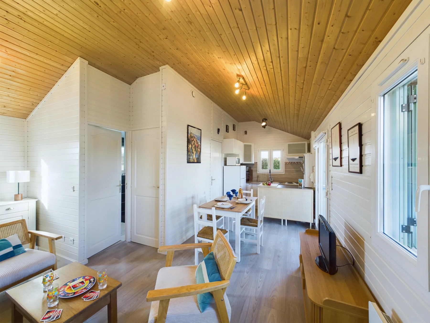 A bright open-plan living and dining area with a kitchen at the back.