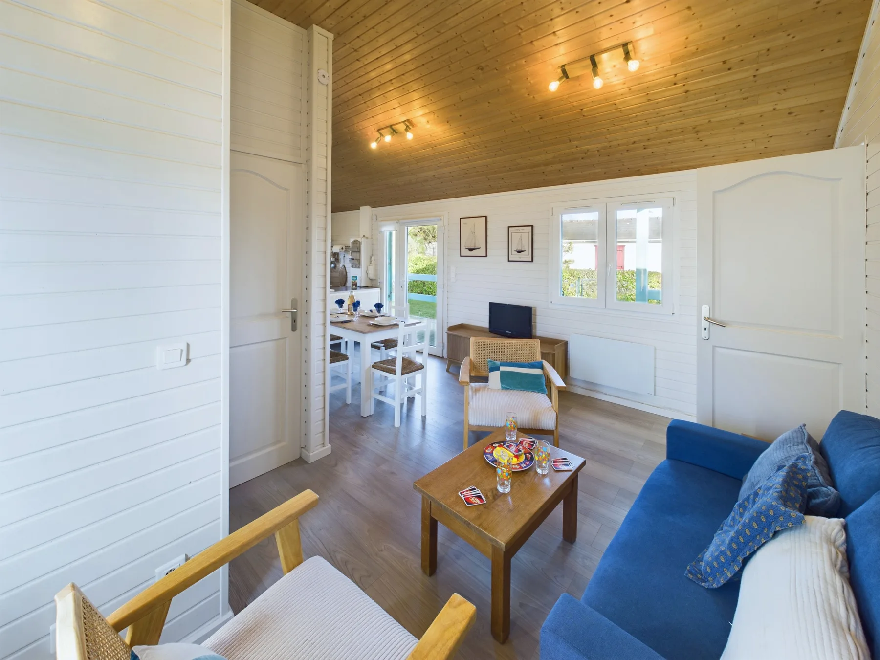 A bright living room with seating, a coffee table, and windows.