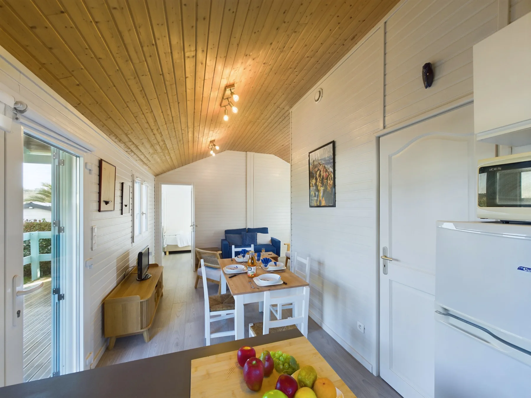A bright bungalow living and dining area with a table and seating.
