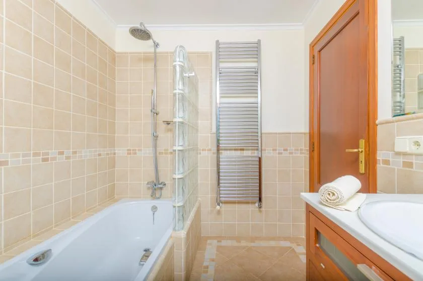A tiled bathroom with a bathtub, shower, and sink.