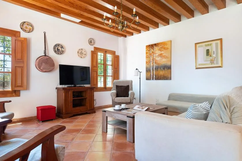 A living room with seating, a television, and a wooden coffee table.