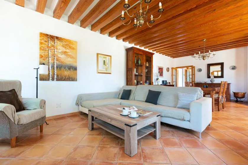 A living room with seating, a coffee table, and a wooden-beam ceiling.