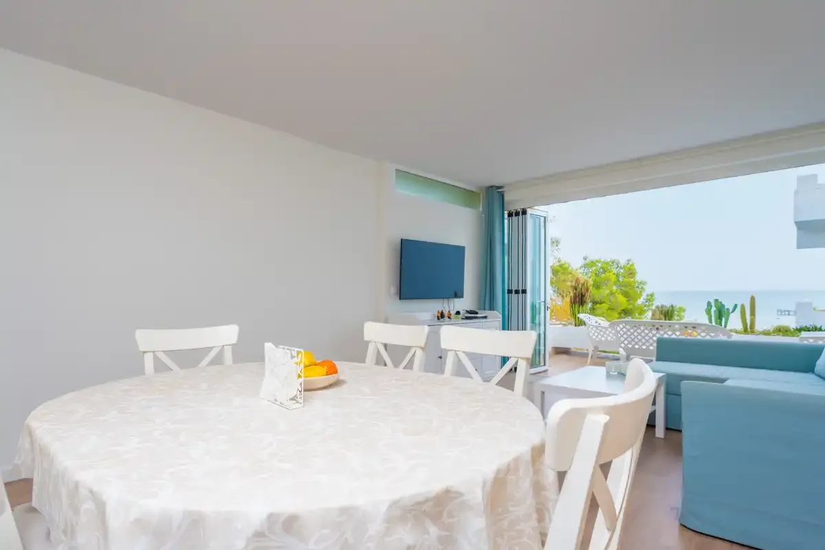 Un comedor luminoso con una mesa redonda junto a una puerta corredera de cristal.