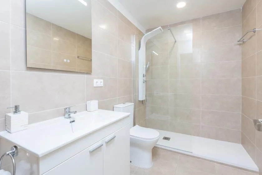 Un baño alicatado con lavabo, inodoro y ducha.