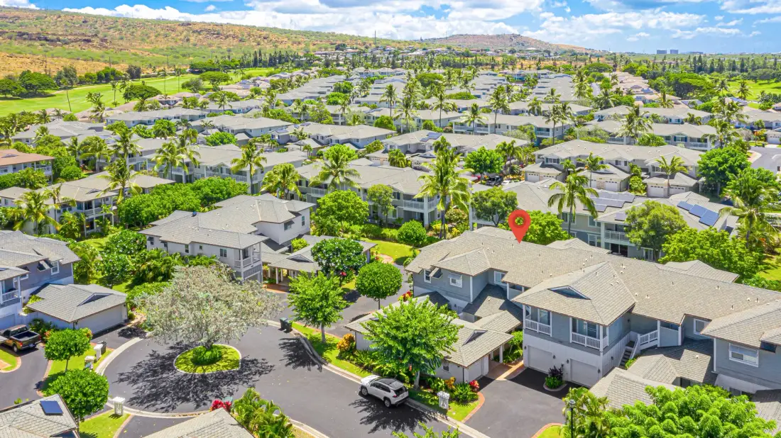 Vista aérea de un vecindario residencial con casas, árboles y calles curvas.