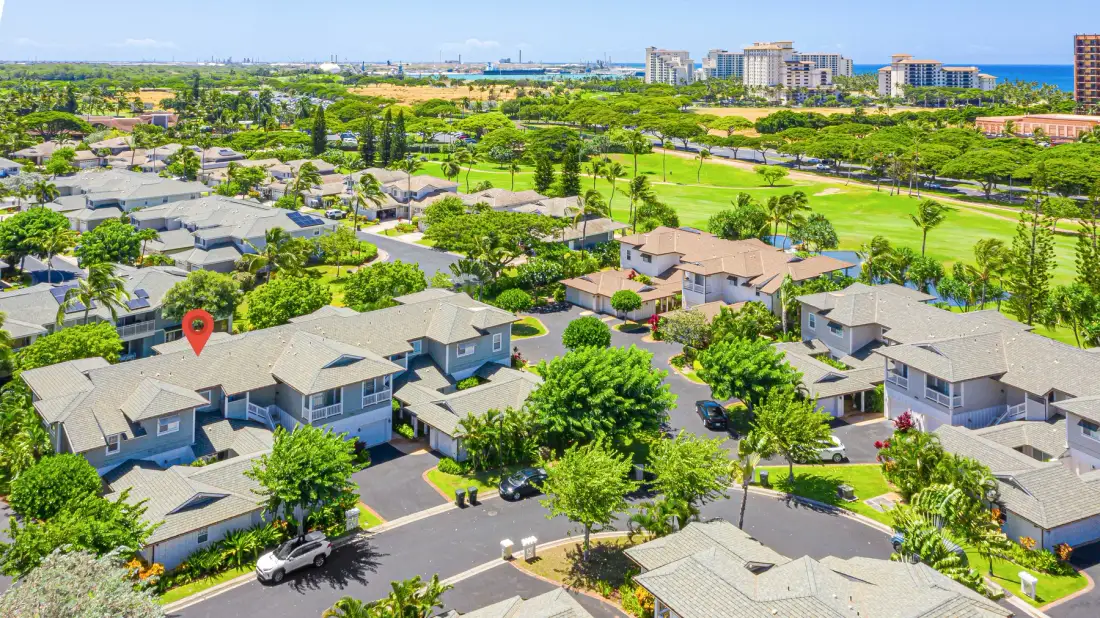 Vista aérea de un vecindario residencial junto a un parque verde.