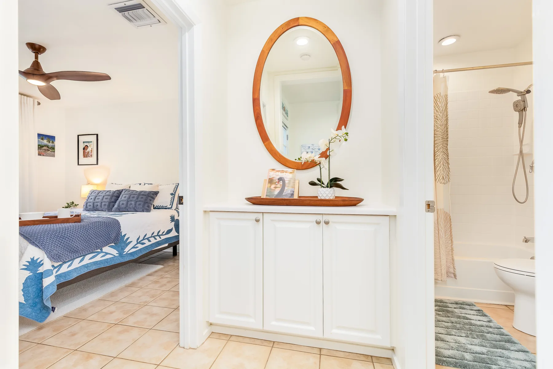 Se ven un dormitorio, un baño y un tocador a través de una puerta abierta.