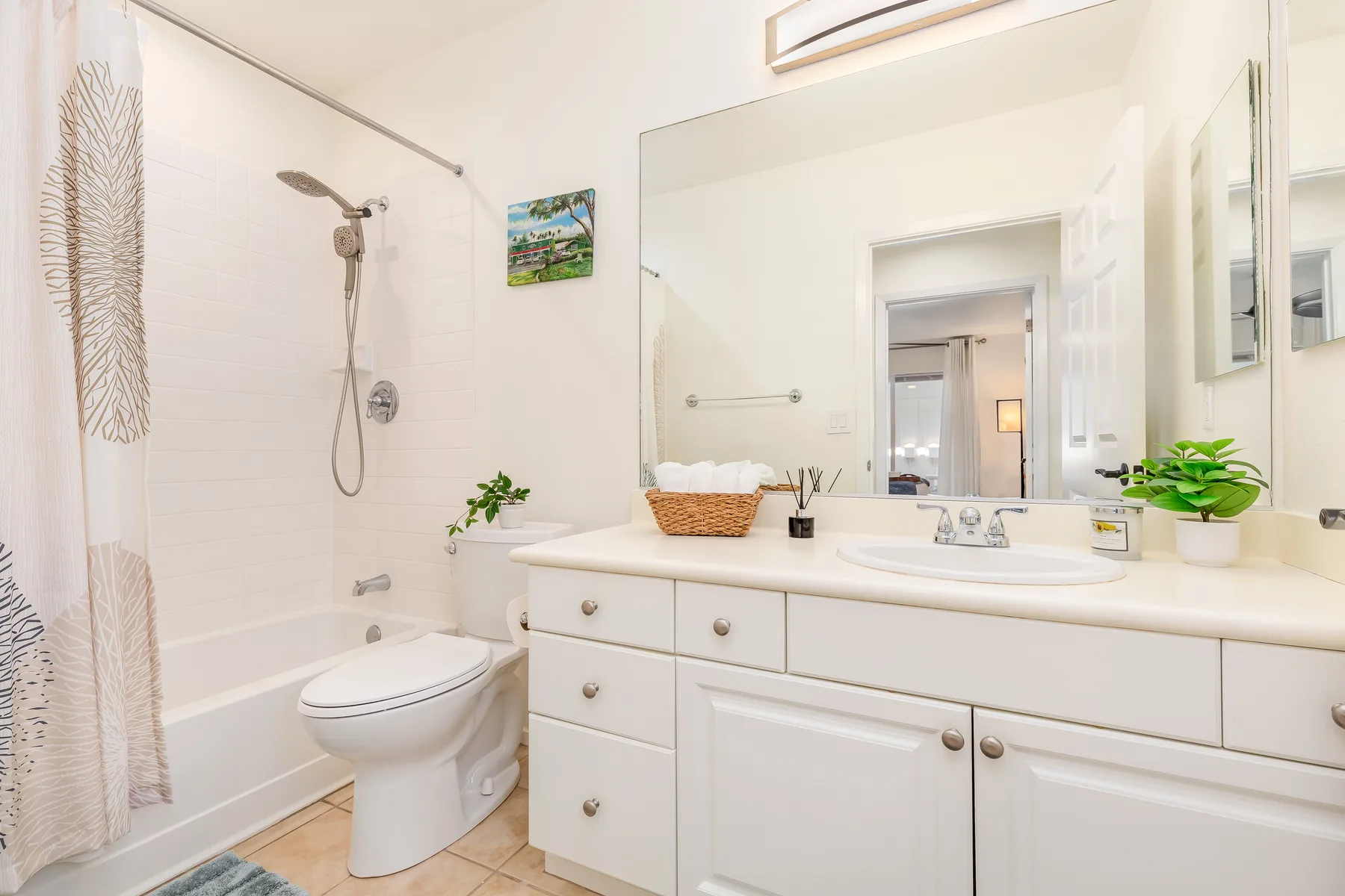 Un baño luminoso con bañera, inodoro y un amplio tocador.