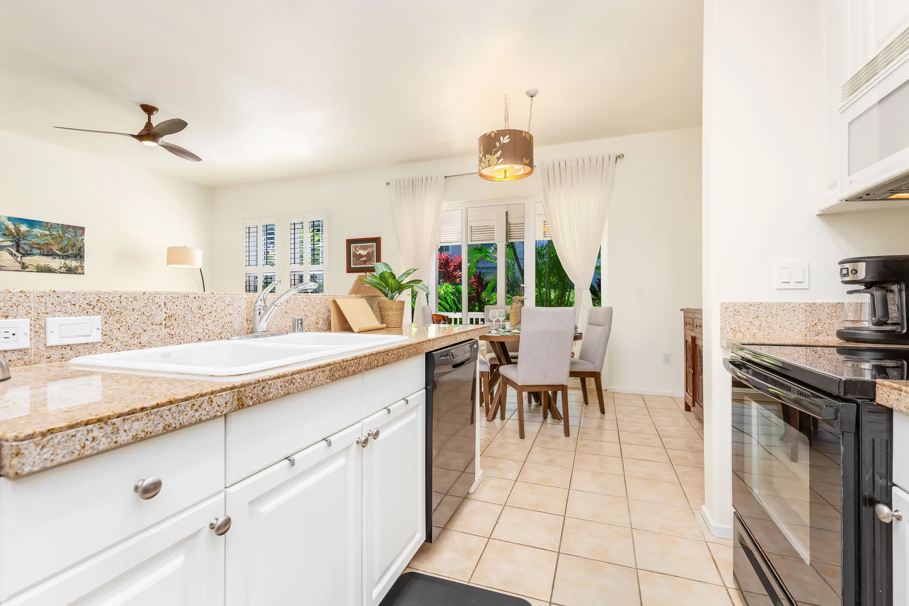 Una cocina y comedor luminosos, con una encimera larga y una mesa junto a las ventanas.