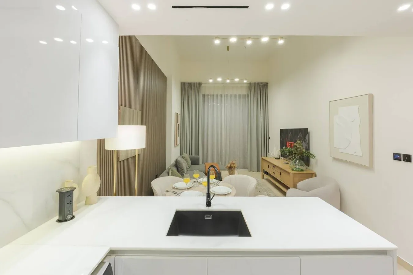 A bright open-plan living area with a kitchen island and seating by the window.