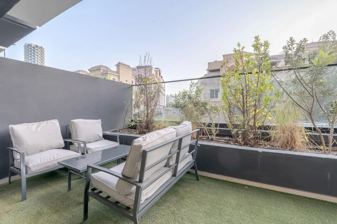 An outdoor seating area with cushioned furniture beside planter boxes.