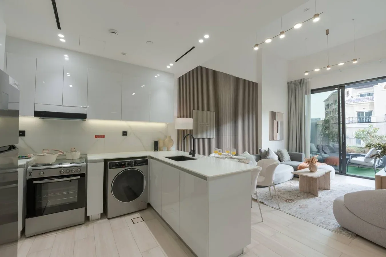 An open-plan kitchen and living area with a central island and seating by the windows.