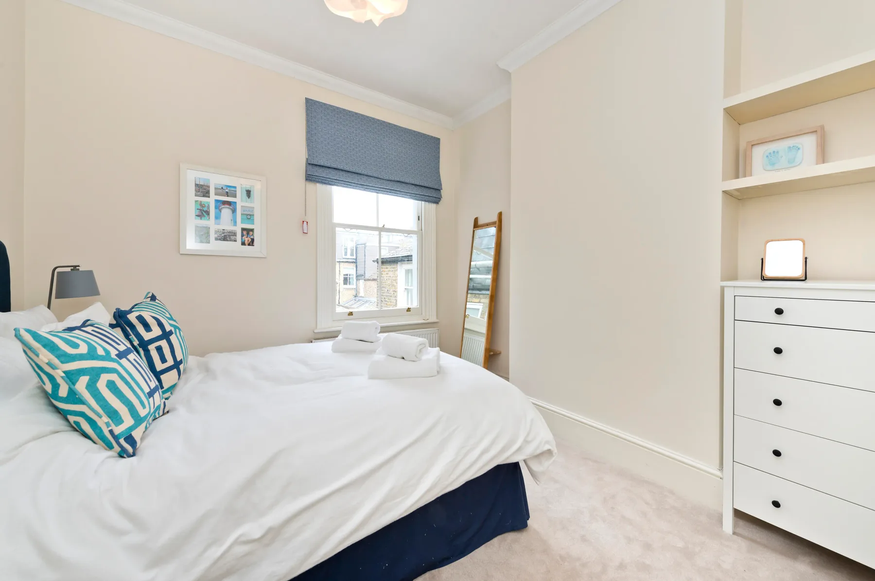 A bright bedroom with a neatly made bed and a window.