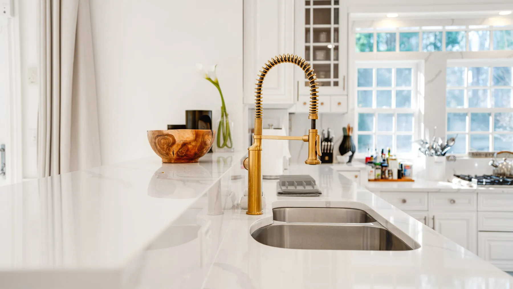 Una cocina luminosa con un fregadero doble y una ventana grande.