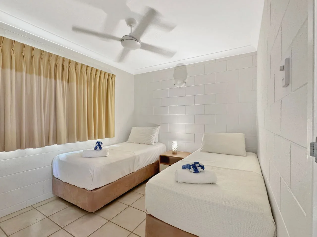 Un dormitorio con dos camas y cortinas que cubren la ventana.
