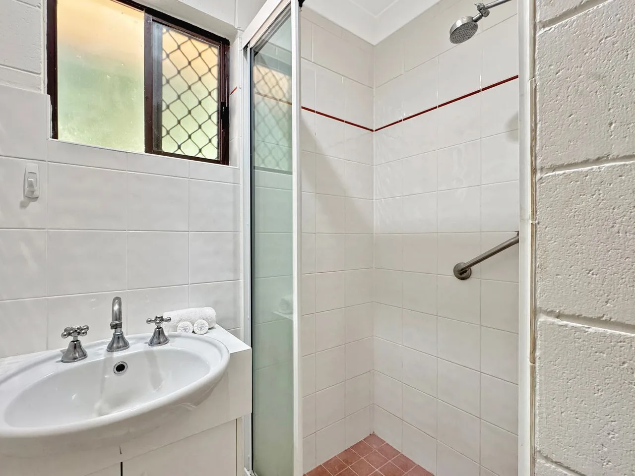 Un baño alicatado con lavabo y ducha.