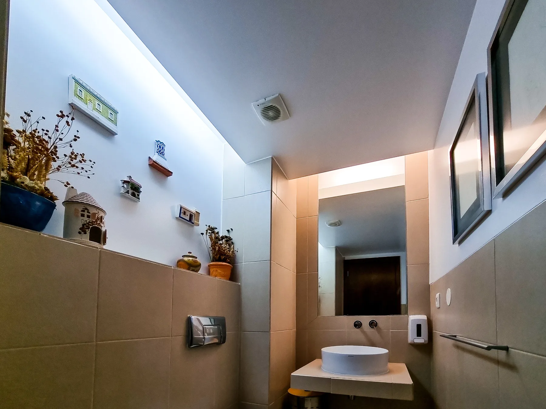 Un baño alicatado con un lavabo y un espejo.