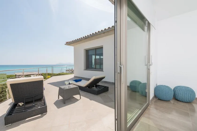 Un patio junto al mar con asientos reclinables tiene vistas al agua.