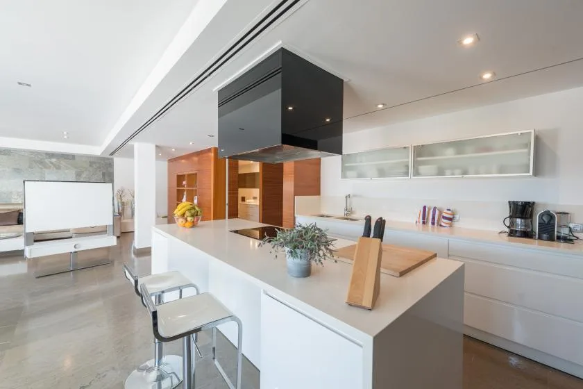 Una cocina moderna con una isla amplia y taburetes.