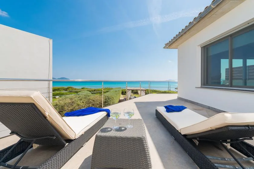 Una terraza junto al mar con tumbonas reclinables y vistas al océano.
